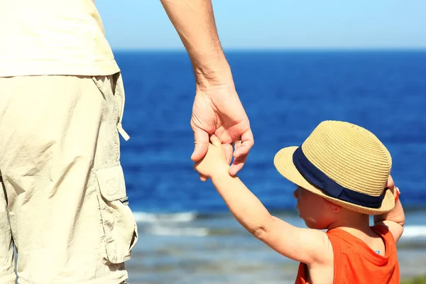 Parent holds the child's hand on the sea — Stock Photo, Image