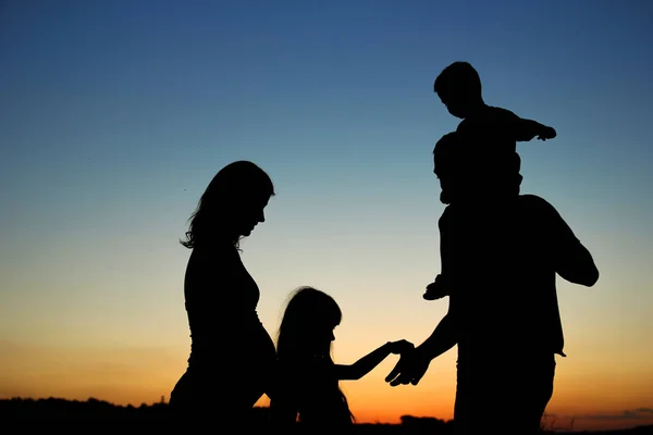 Silhueta de uma família feliz com crianças — Fotografia de Stock