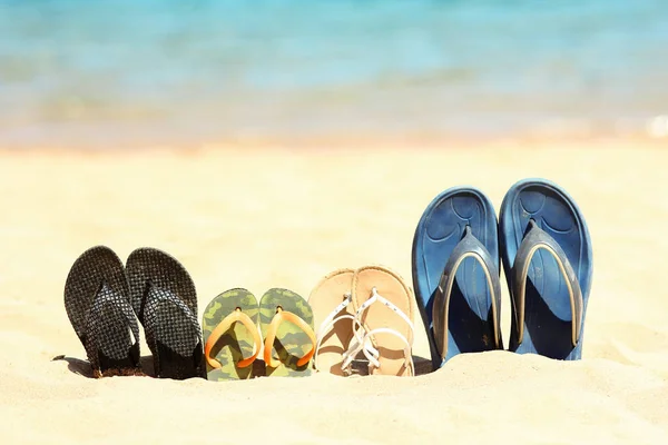 Hausschuhe für die Familie im Sand am Strand — Stockfoto