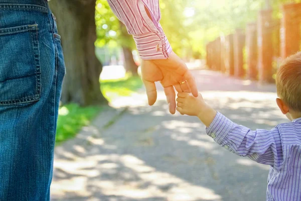 El padre sosteniendo la mano del niño con un fondo feliz —  Fotos de Stock