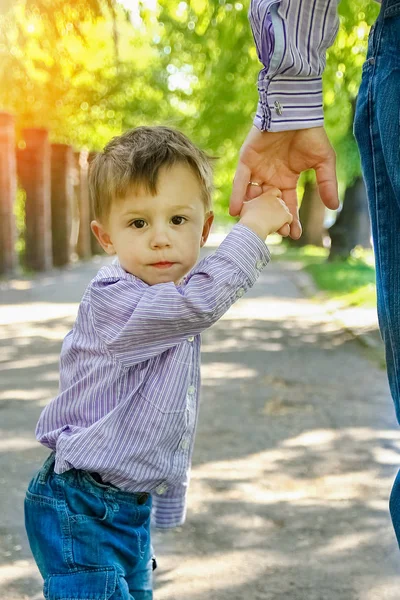 Ο γονέας κρατώντας το χέρι του παιδιού με ένα ευτυχισμένο υπόβαθρο — Φωτογραφία Αρχείου