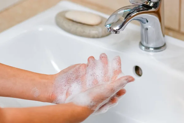 Hygienická koncepce. Mytí rukou mýdlem pod kohoutkem s w — Stock fotografie