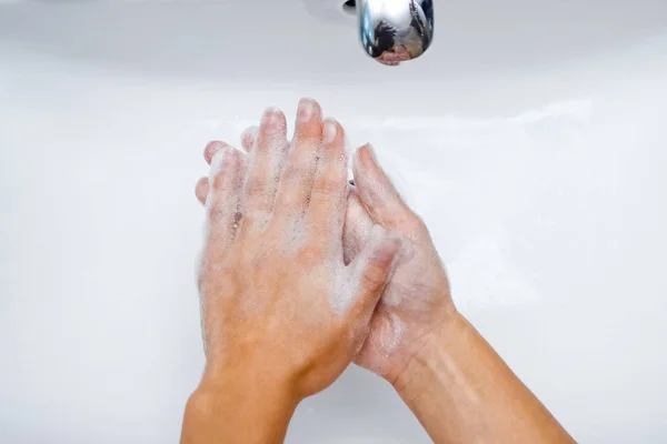 Concetto di igiene. Lavarsi le mani con sapone sotto il rubinetto con w — Foto Stock