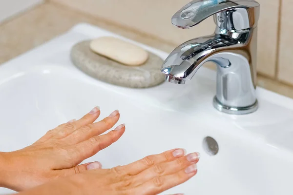 Hygiene concept. Washing hands with soap under the faucet with w