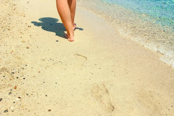 Schöne Beine auf dem Sand am Meer — Stockfoto