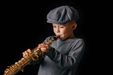 Mutlu çocuk stüdyoda saksafon çalıyor.