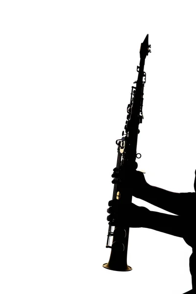 Saxafon på hvit bakgrunn i hendene på en musikalsk silhue – stockfoto
