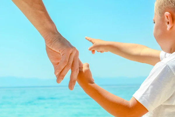 Feliz papá toma la mano de un niño por el mar griego en la naturaleza —  Fotos de Stock