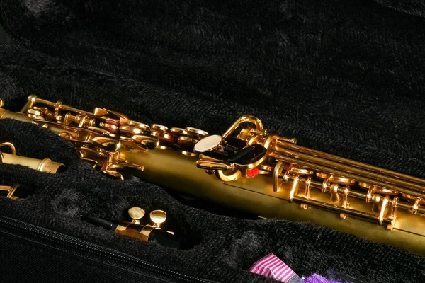 soprano saxophone in a case on a black background