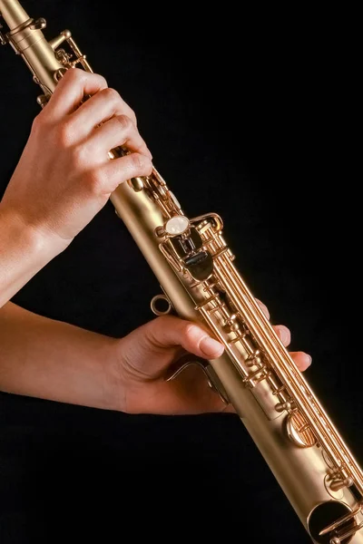 Saxophone soprano dans les mains d'une fille sur fond noir — Photo