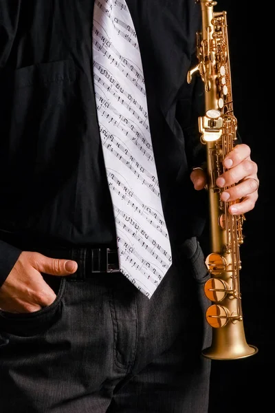 Saxophone soprano dans les mains d'un mec sur fond noir — Photo
