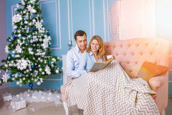 Happy couple at home on christmas day together — ストック写真