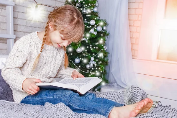 Enfant heureux lisant un livre à Noël — Photo