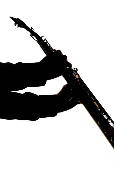 Саксафон на білому тлі в руках музиканта силуету — стокове фото