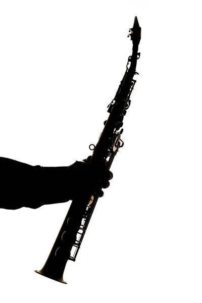 Saxafon auf weißem Hintergrund in den Händen einer Musiker-Silhouette — Stockfoto