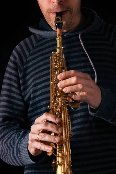 Saxophone soprano dans les mains d'un mec sur fond noir — Photo