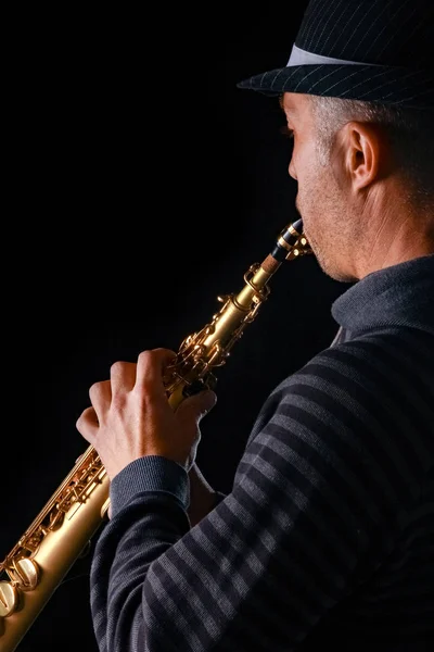 Saxofón soprano en las manos de un chico sobre un fondo negro — Foto de Stock