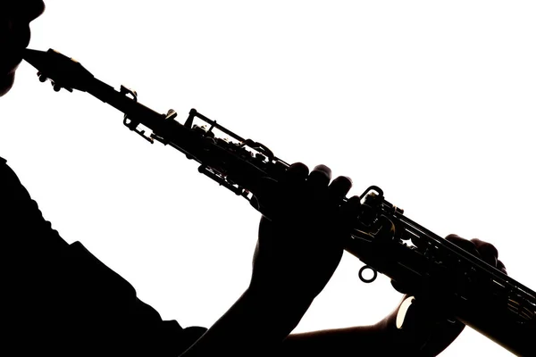 Saxafón sobre fondo blanco en manos de un músico silue — Foto de Stock