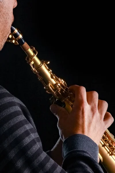 Soprán saxofon v rukou člověka na černém pozadí — Stock fotografie