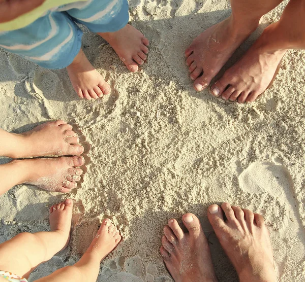 Familie voeten op het zand op het strand — Stockfoto