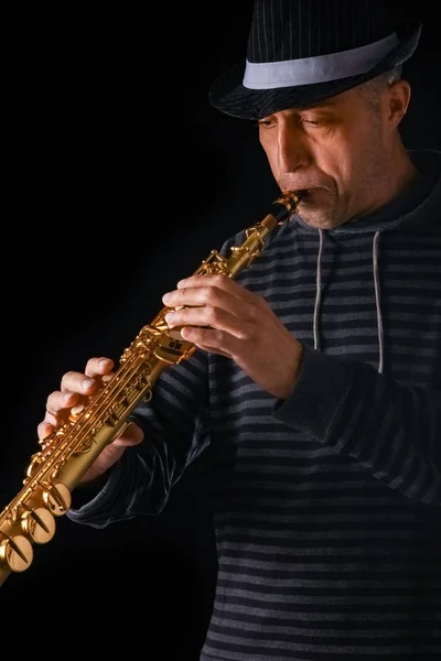 Soprano saxofone nas mãos de um cara em um fundo preto — Fotografia de Stock