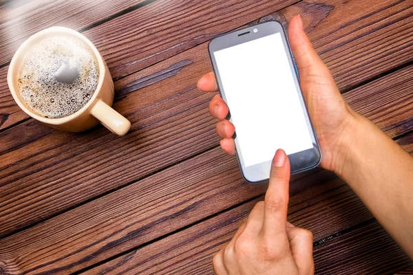 Vrouwelijke handen met kopje koffie op houten achtergrond — Stockfoto