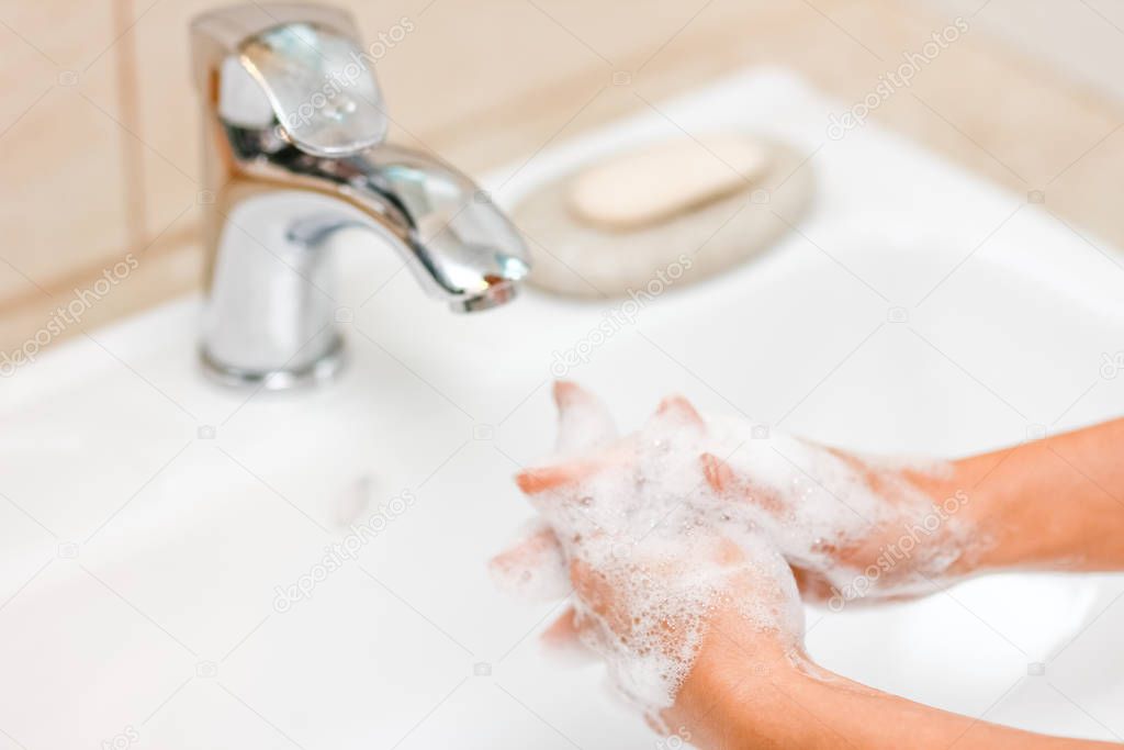 Hygiene concept. Washing hands with soap under the faucet with w