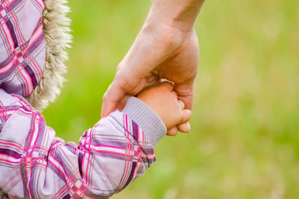 Handen Gelukkig ouders en kind buiten in het park — Stockfoto