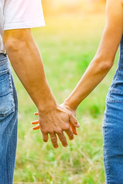 Χέρια ενός ευτυχισμένου ζευγαριού ερωτευμένων σε εξωτερικούς χώρους στο καλοκαιρινό πάρκο — Φωτογραφία Αρχείου