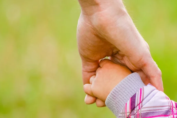 Handen Gelukkig ouders en kind buiten in het park — Stockfoto