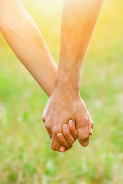 Händer av ett lyckligt par kär utomhus i sommarparken — Stockfoto