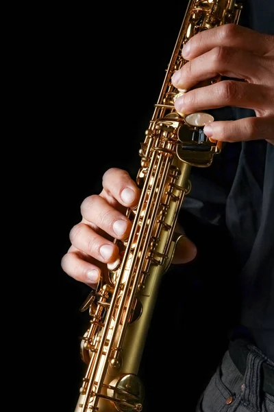 Saxofón soprano en manos sobre fondo negro — Foto de Stock