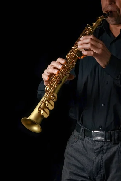 Saxofón soprano en manos sobre fondo negro — Foto de Stock