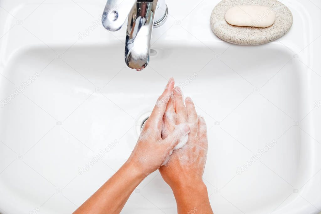 Hygiene concept. Washing hands with soap under the faucet with w