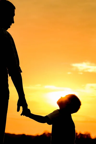 Happy dad with a child in the park outdoors silhouette — Stock Photo, Image