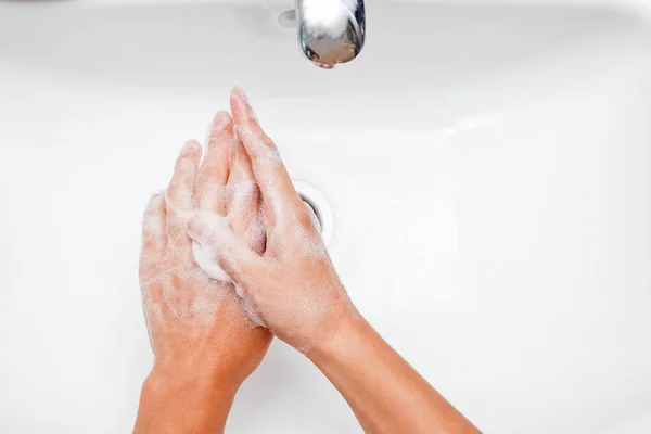 Concepto de higiene. Lavarse las manos con jabón debajo del grifo con w —  Fotos de Stock