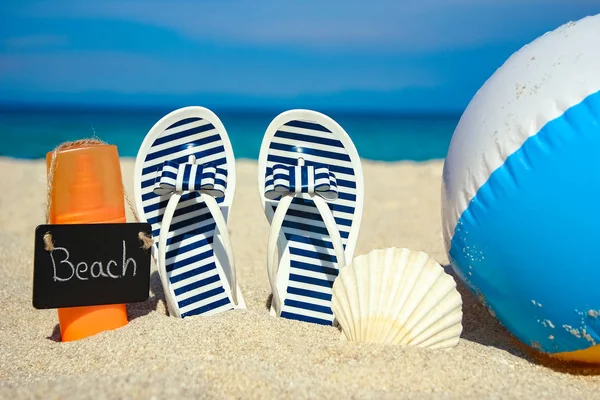 Hermosas zapatillas en la arena del mar en Grecia fondo —  Fotos de Stock