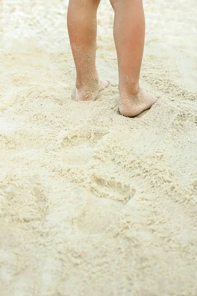 Beautiful legs on the sand by the sea — Stock Photo, Image