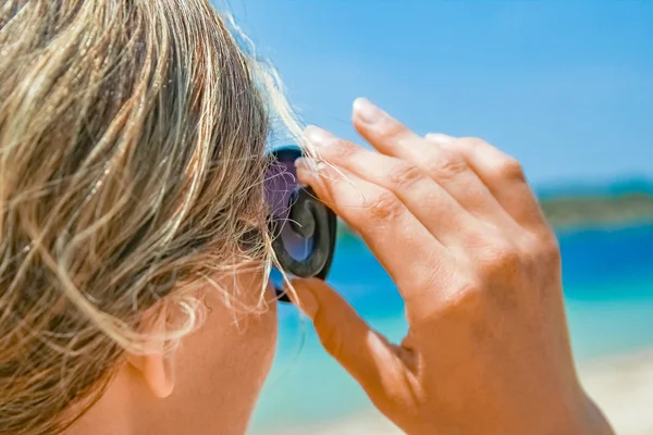 Happy girl with sunglasses by the sea on nature background — Stock Photo, Image