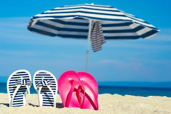 Nádherné pantofle v mořském písku na pozadí Řecka — Stock fotografie