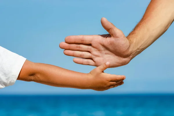 Feliz papá toma la mano de un niño por el mar griego en la naturaleza —  Fotos de Stock