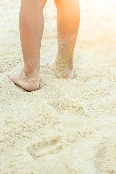 Beautiful legs on the sand by the sea — Stock Photo, Image