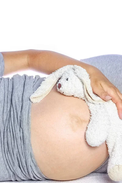 Menina grávida feliz encontra-se no fundo branco — Fotografia de Stock