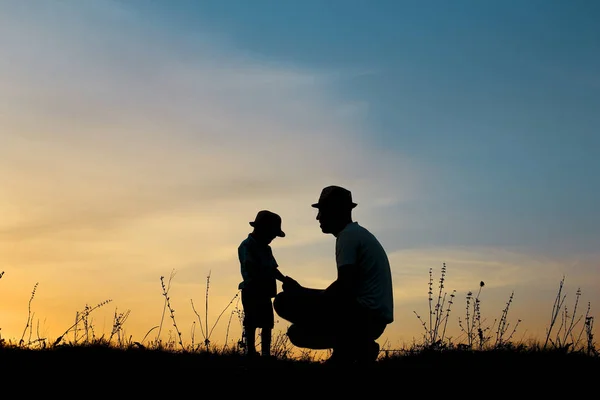 Silueta otce a syna hrát při západu slunce — Stock fotografie