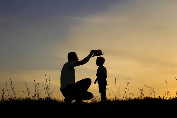 Silueta otce a syna hrát při západu slunce — Stock fotografie