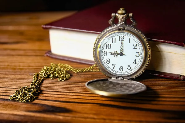 Een zakhorloge met boekachtergrond — Stockfoto