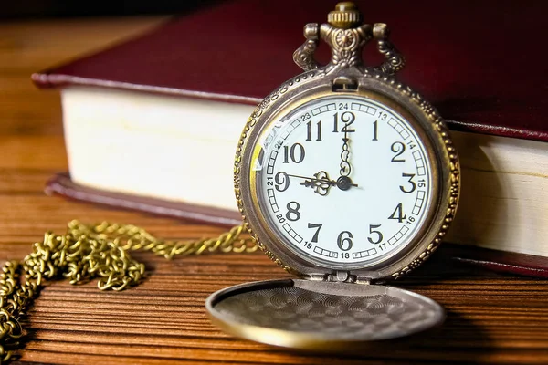 a pocket watch with book background