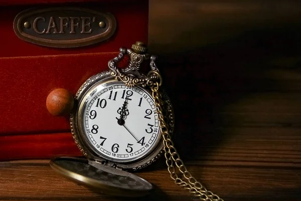 Un reloj de bolsillo con un molinillo de café sobre un fondo de madera — Foto de Stock