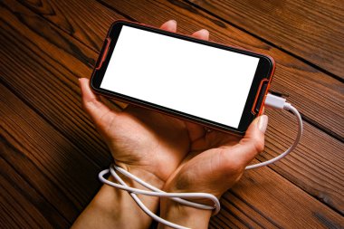 Telefon ahşap bir arka planda el bağımlılığı