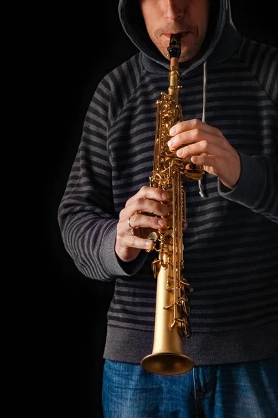 Saxofón soprano en las manos de un chico sobre un fondo negro —  Fotos de Stock